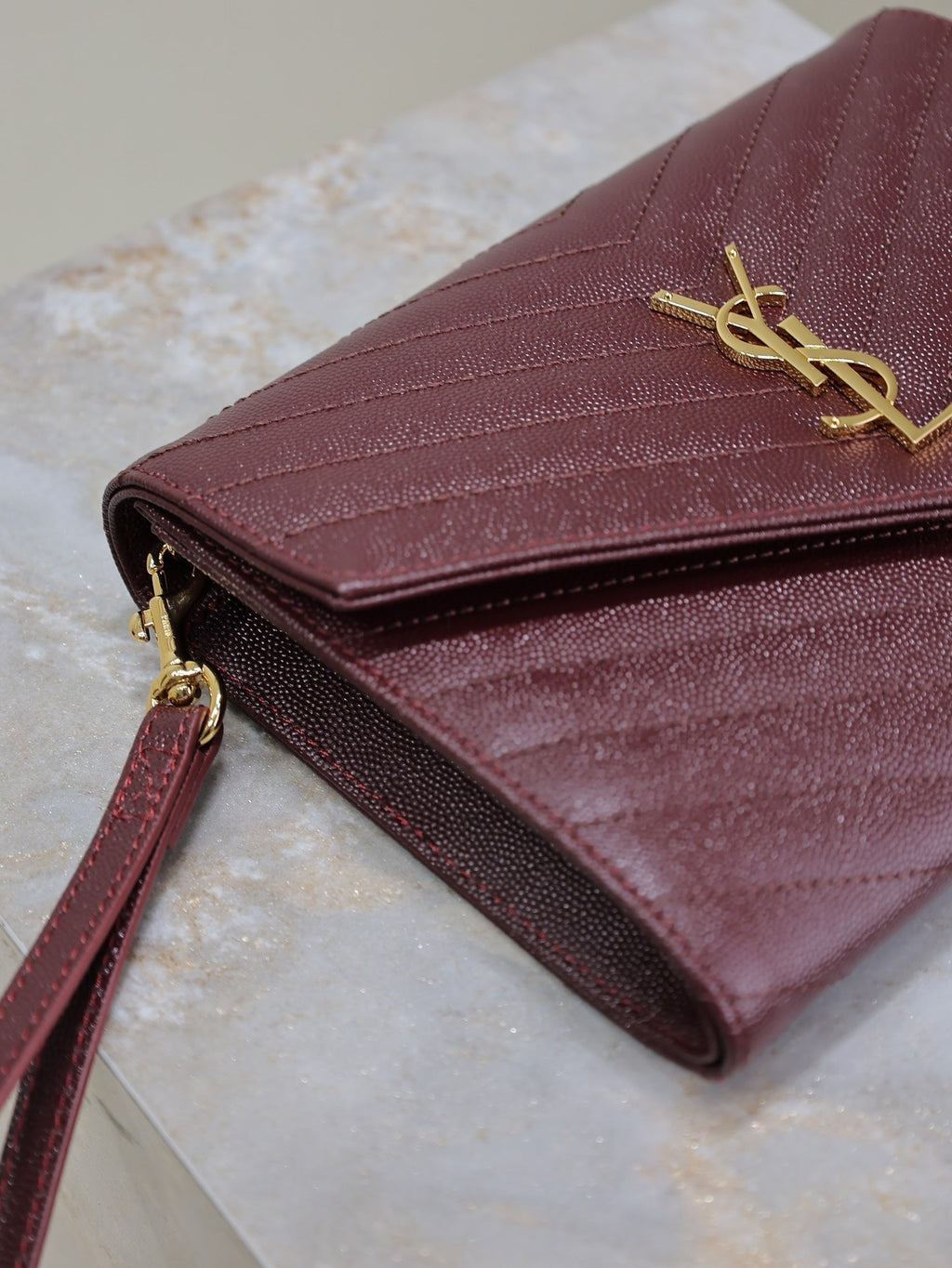 CASSANDRE CLUTCH 21 IN BORDEAUX RED LAMBSKIN GOLD HARDWARE